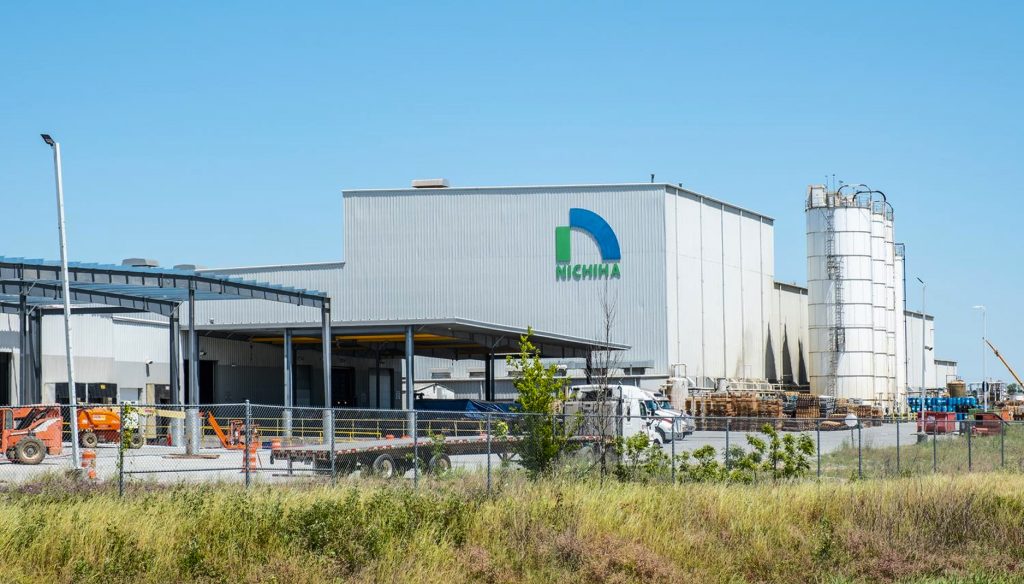 Exterior of a Nichiha manufacturing plant with the company logo on the building