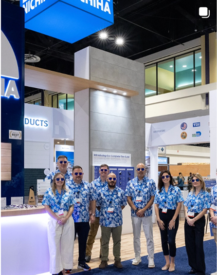 Nichiha team members in matching floral shirts at the company trade show booth