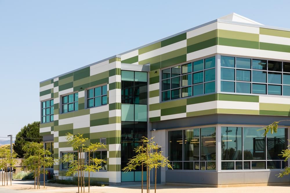 A close-up shot of Mount Eden High School utilizing Nichiha&rsquo;s Illumination fiber cement cladding in custom shades of green and white.