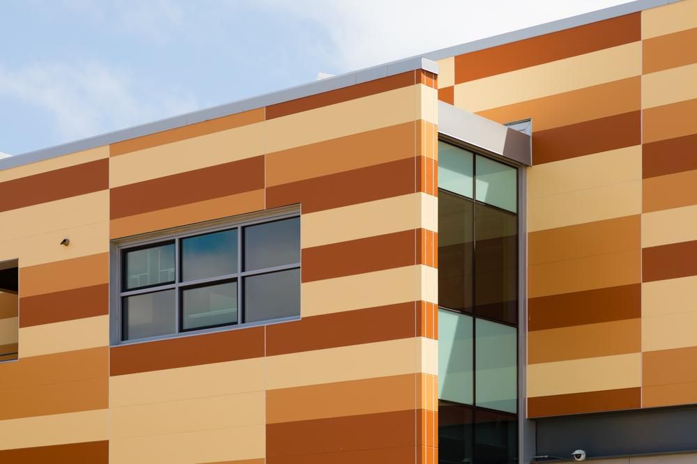 A close-up shot of Hayward High School utilizing Nichiha&rsquo;s Illumination fiber cement cladding in three different shades of orange.