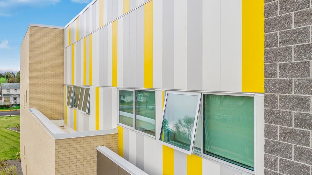 Nichiha&rsquo;s Illumination panels in Gray, Smoke, and Citrus, shine bright against the sunlight at Franklin Elementary School. 