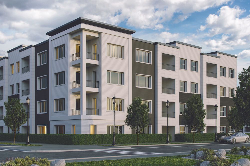 A street-view of a multi-family building with white and dark gray fiber cement siding.