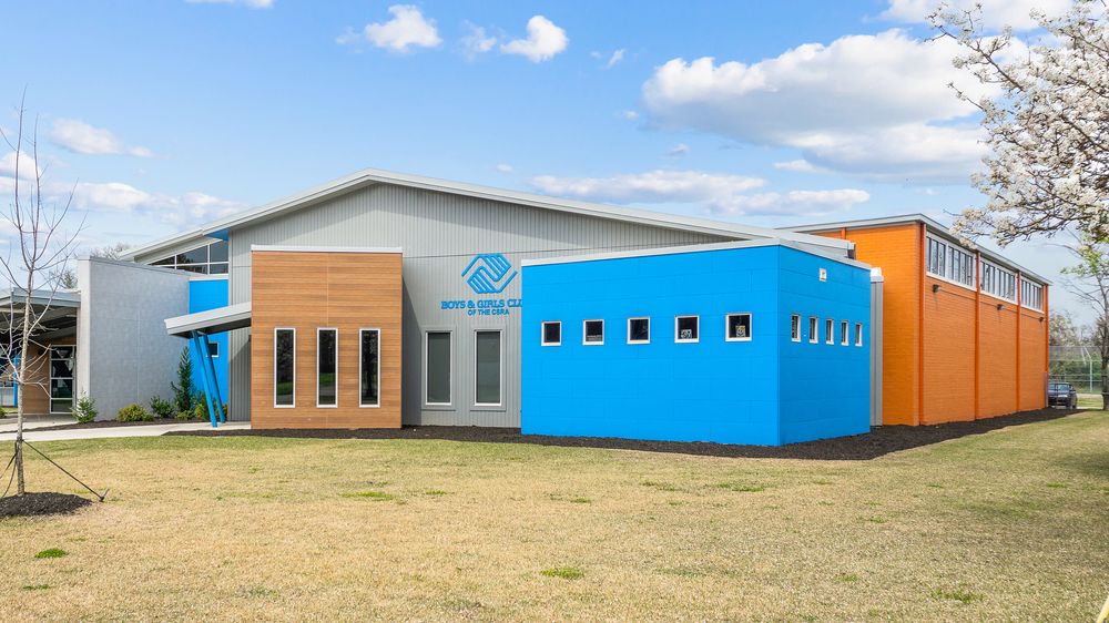 A Boys & Girls Club with sections of blue and orange fiber cement siding off the main gray building.