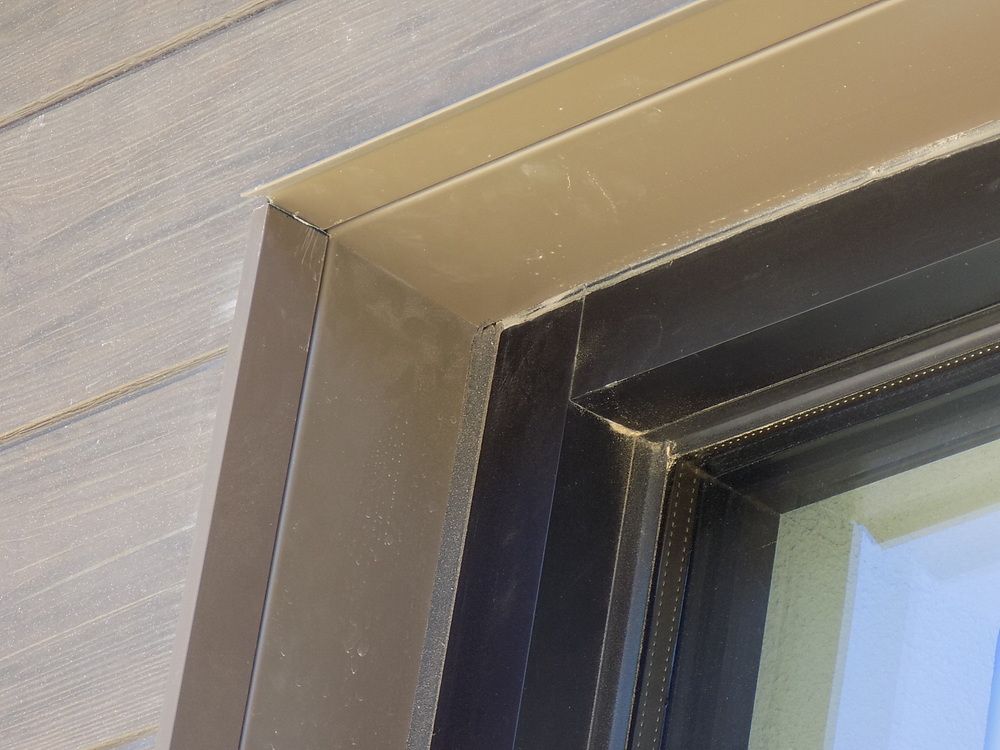 The corner of a window with black Nichiha J-Mold and J-Trim surrounded by Vintage Wood fiber cement panels.
