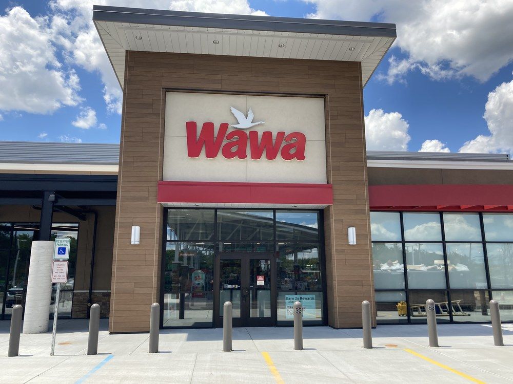 A shot of Wawa’s convenience store with their red logo utilizing Nichiha’s fiber cement cladding in brown and light tan.